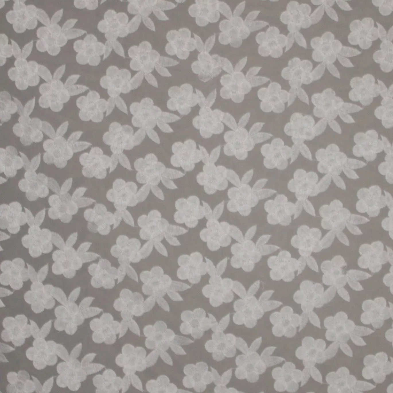 Organza met witte geborduurde bloemen.