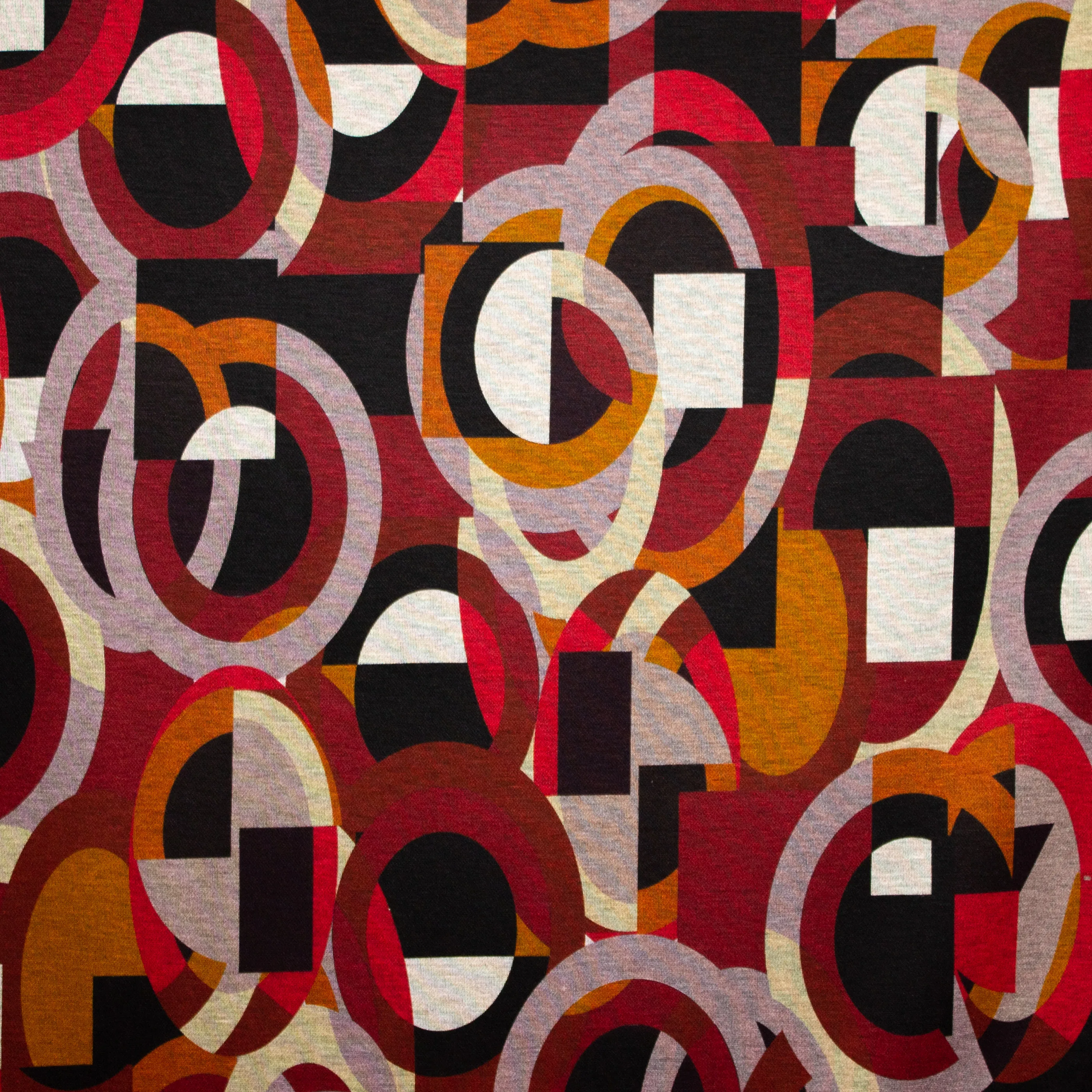 Polyester / viscose mengeling met abstract motief in rode tinten