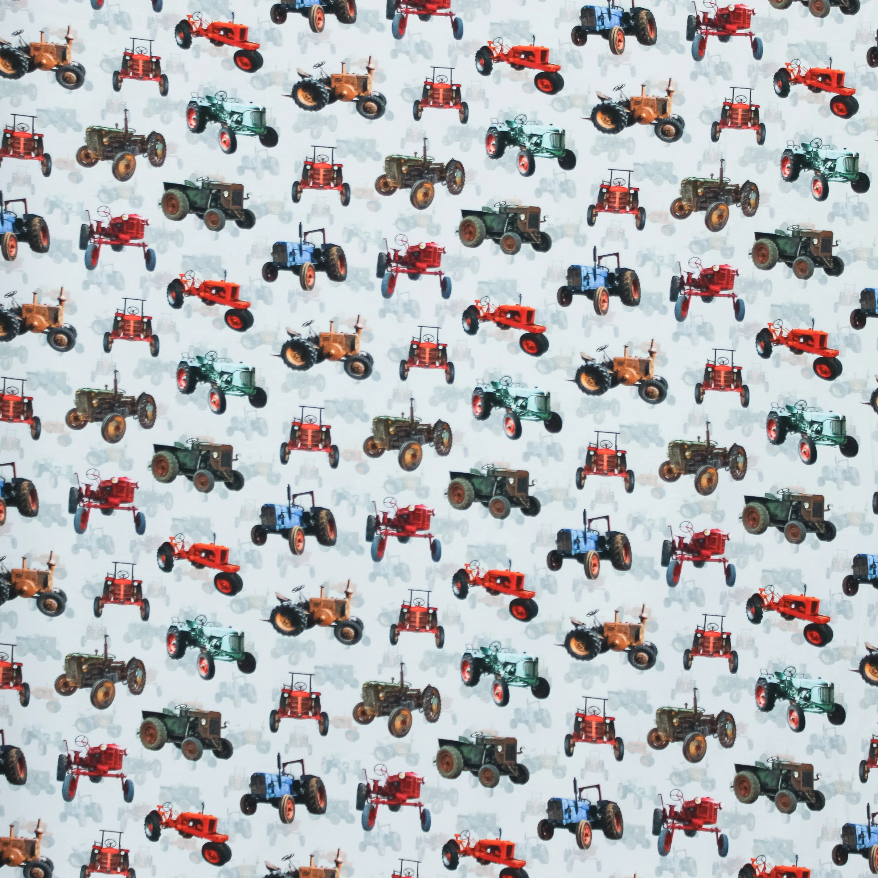 Lichtblauwe tricot met tractor's in de weide