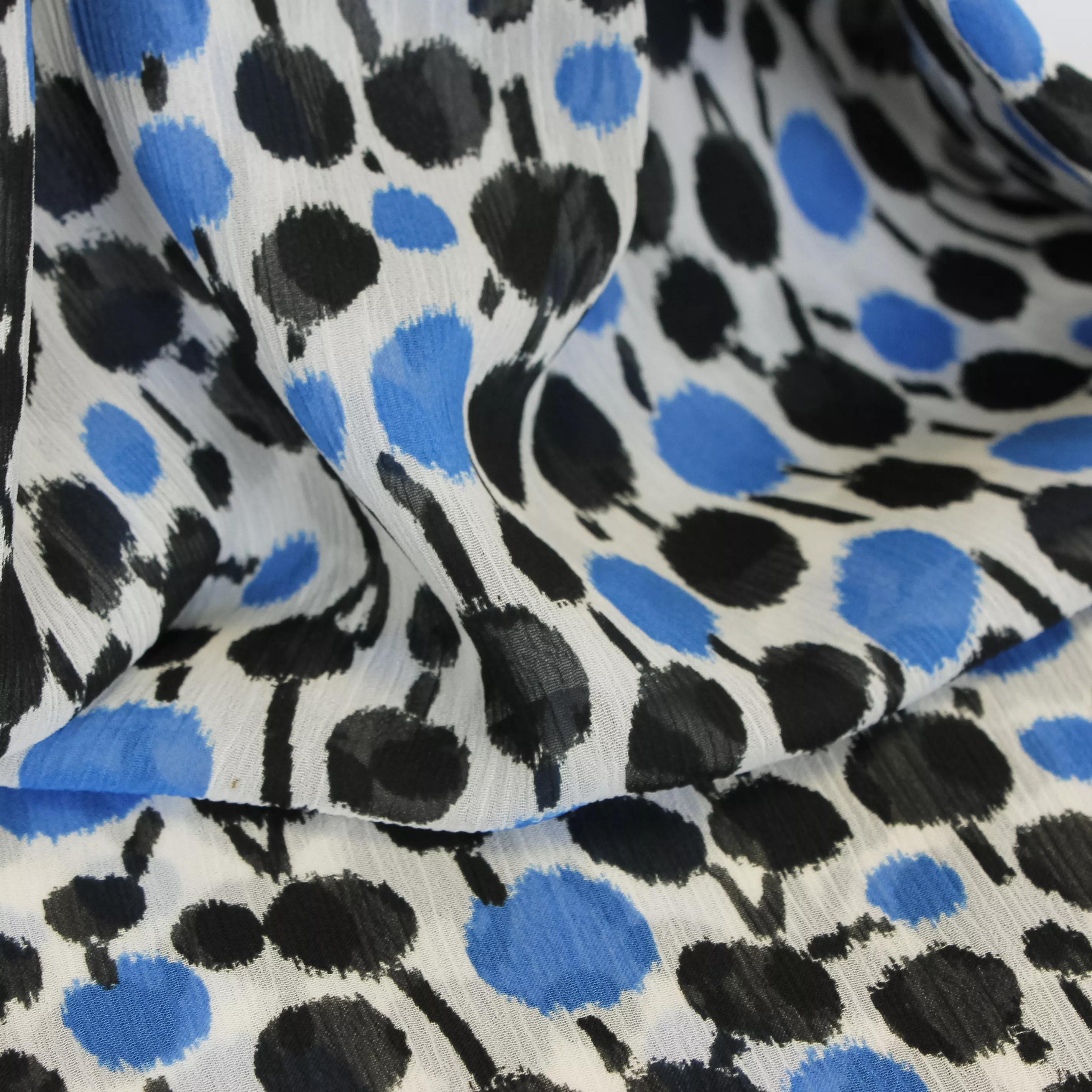 Voile polyester met blauwe en zwarte stippen