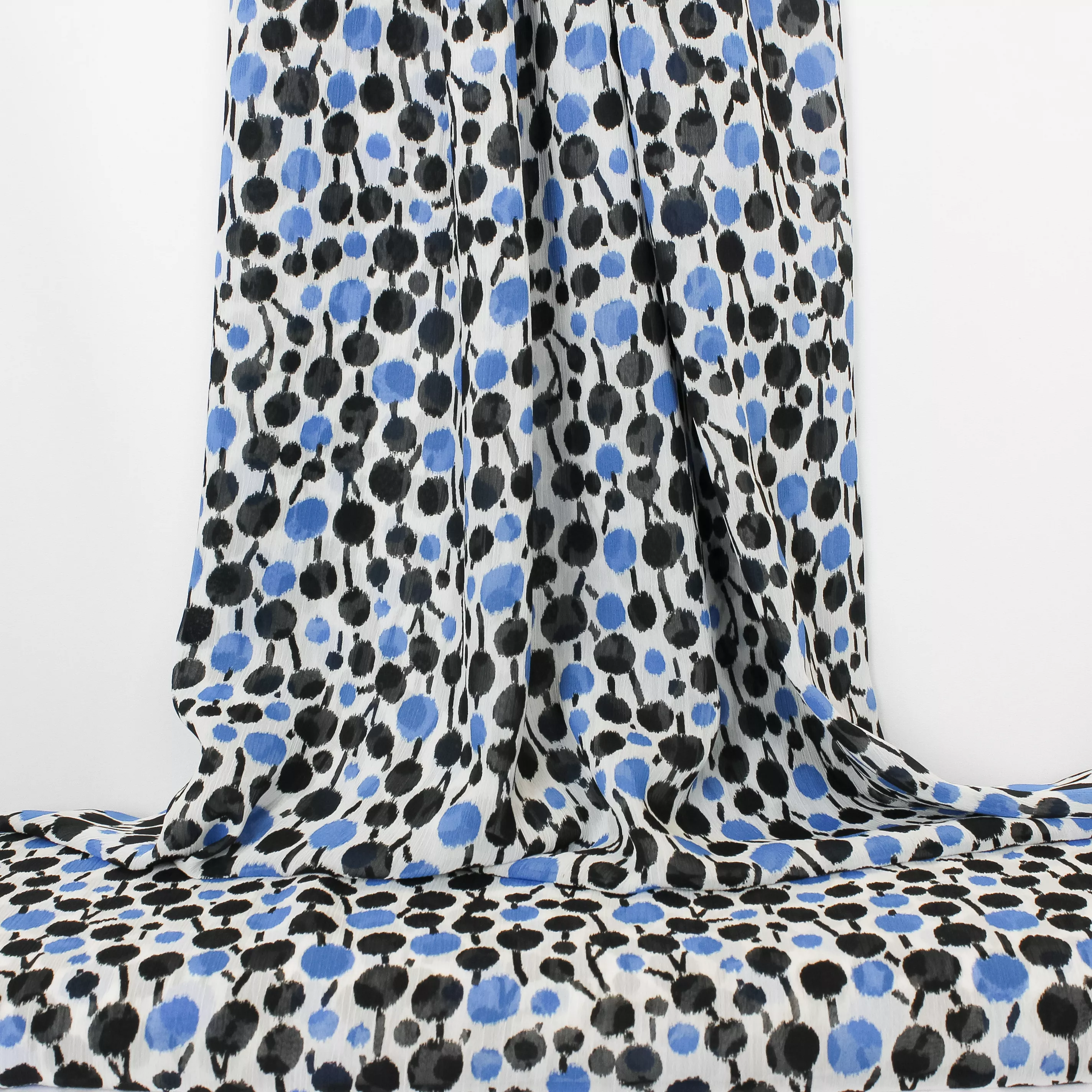 Voile polyester met blauwe en zwarte stippen