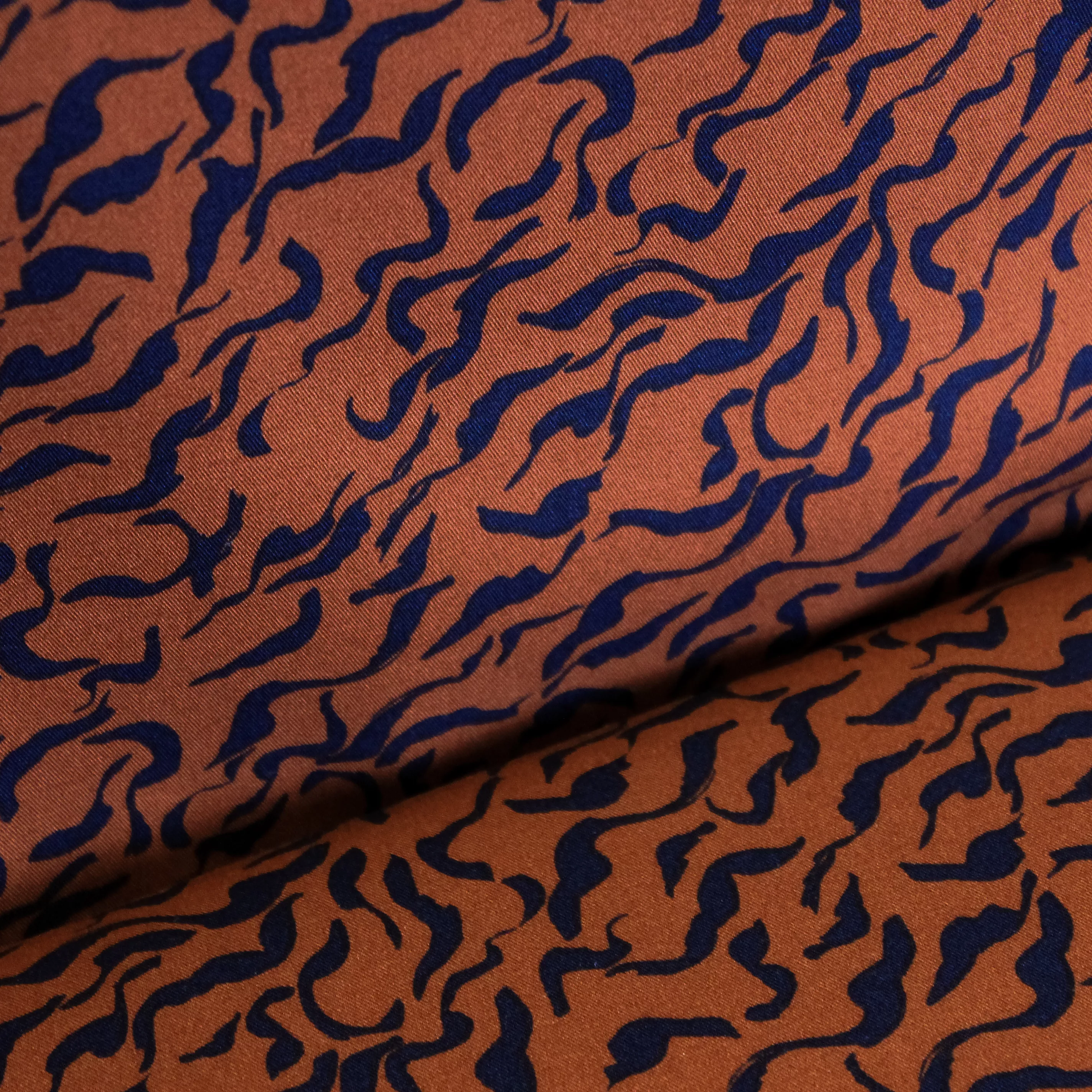 Bruine viscose stretch met zwarte krullen