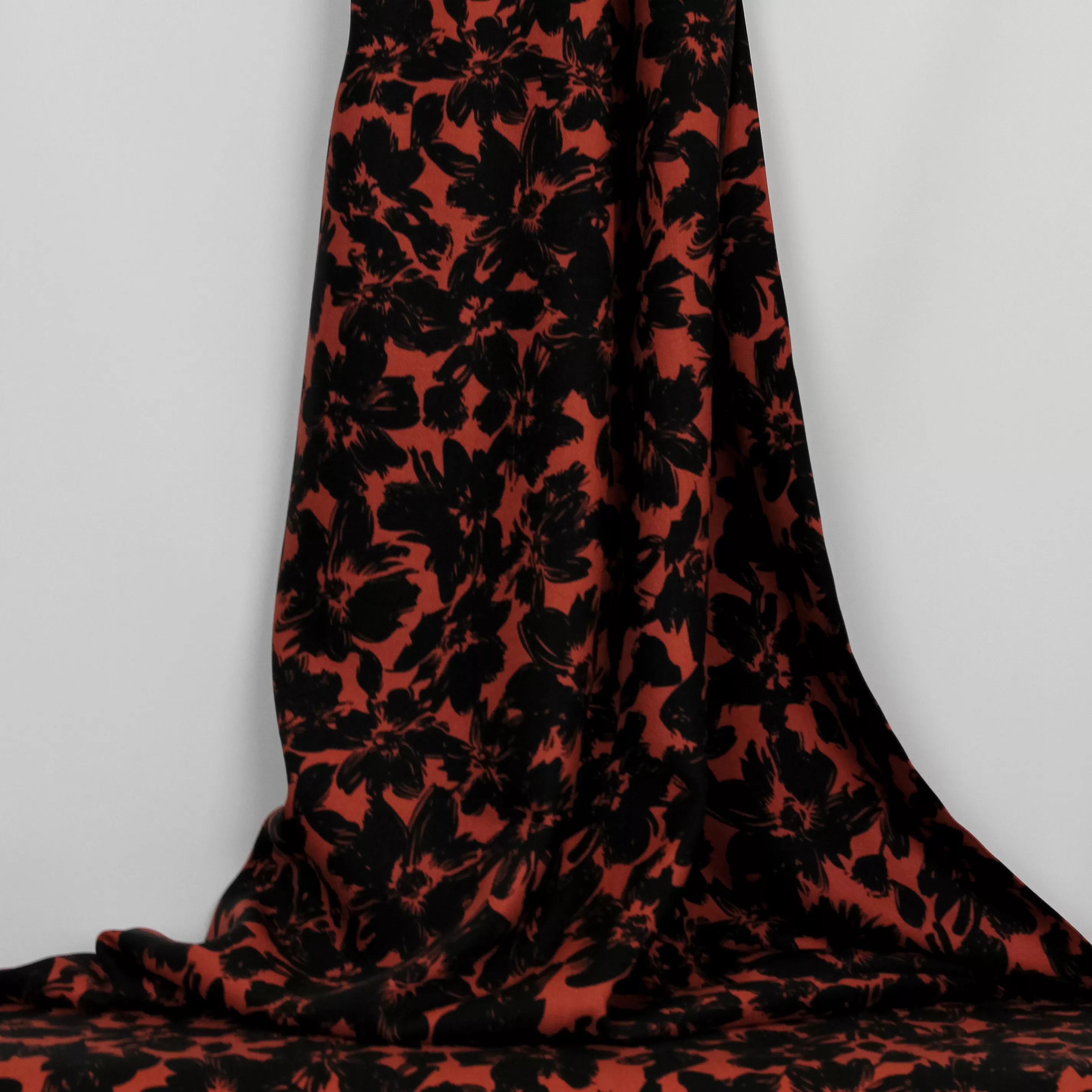 Viscose twill oranjerood met zwarte bloemen