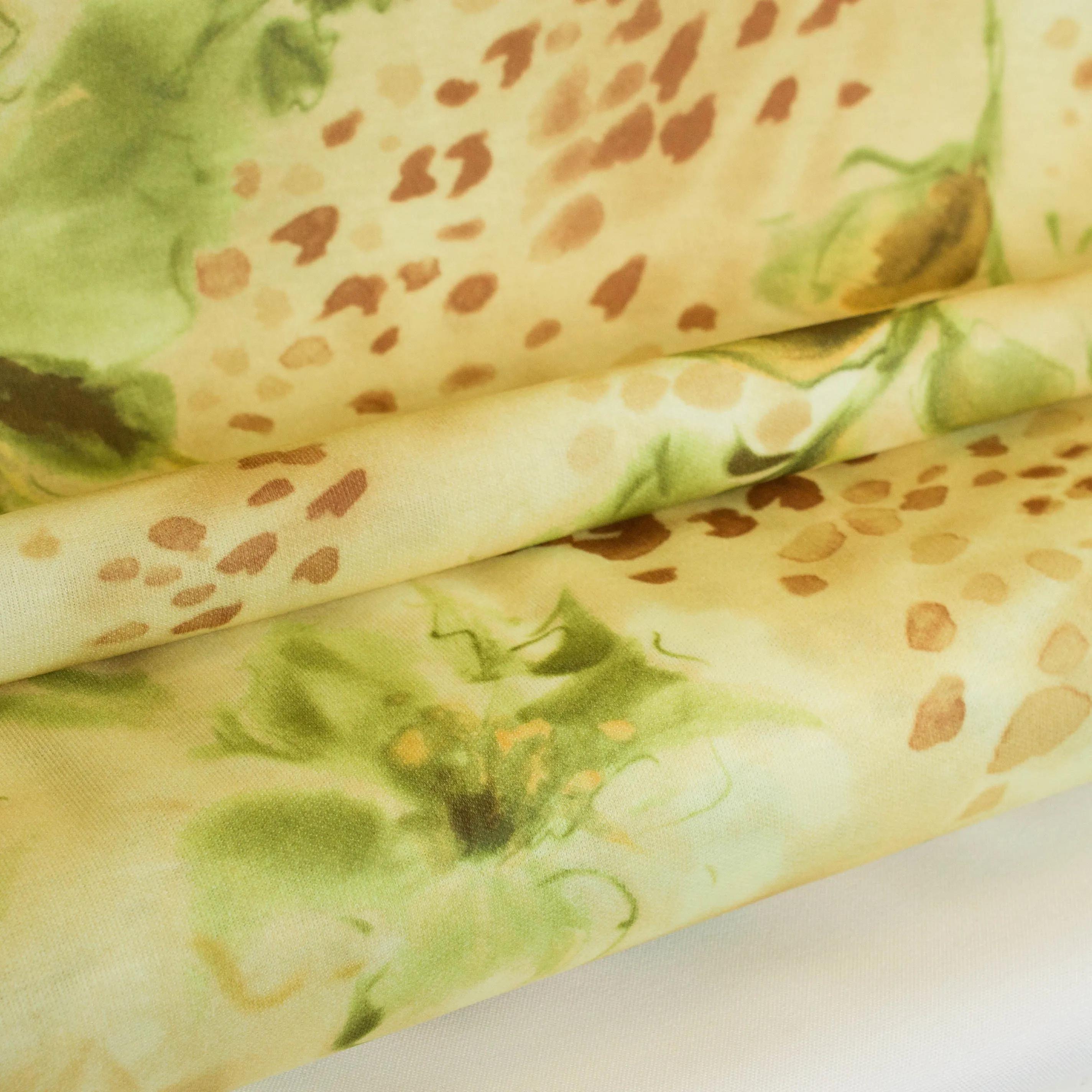 Katoen tricot geel met groene bloemen