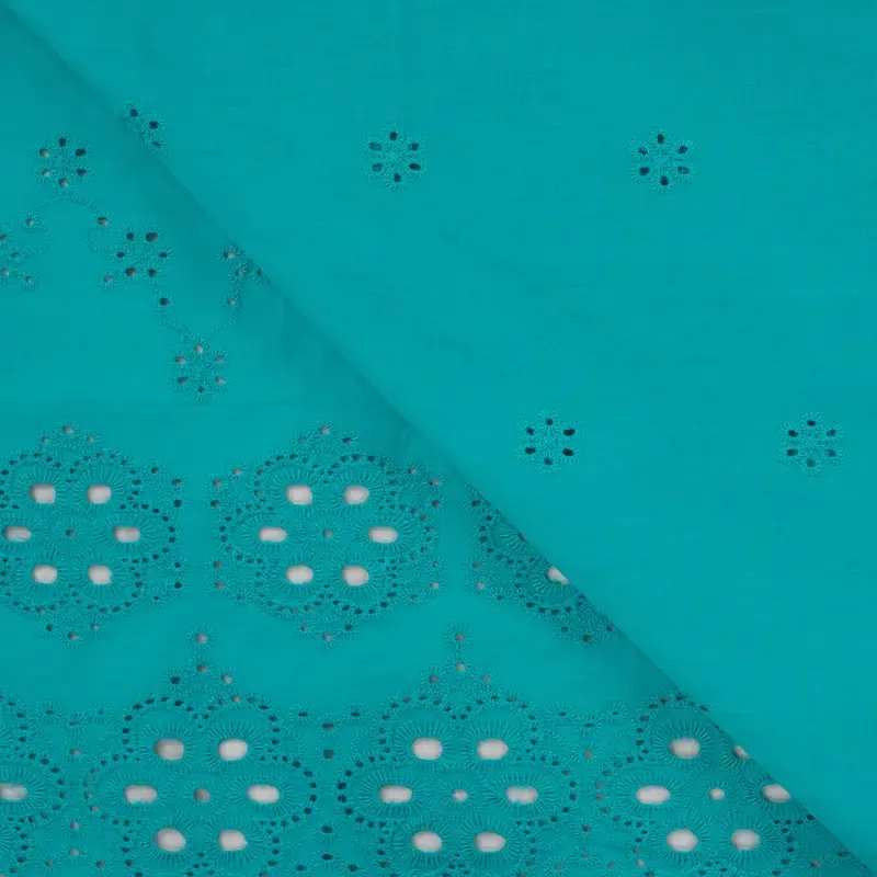 Broderie turquoise met bloemetjes en afgewerkte boord