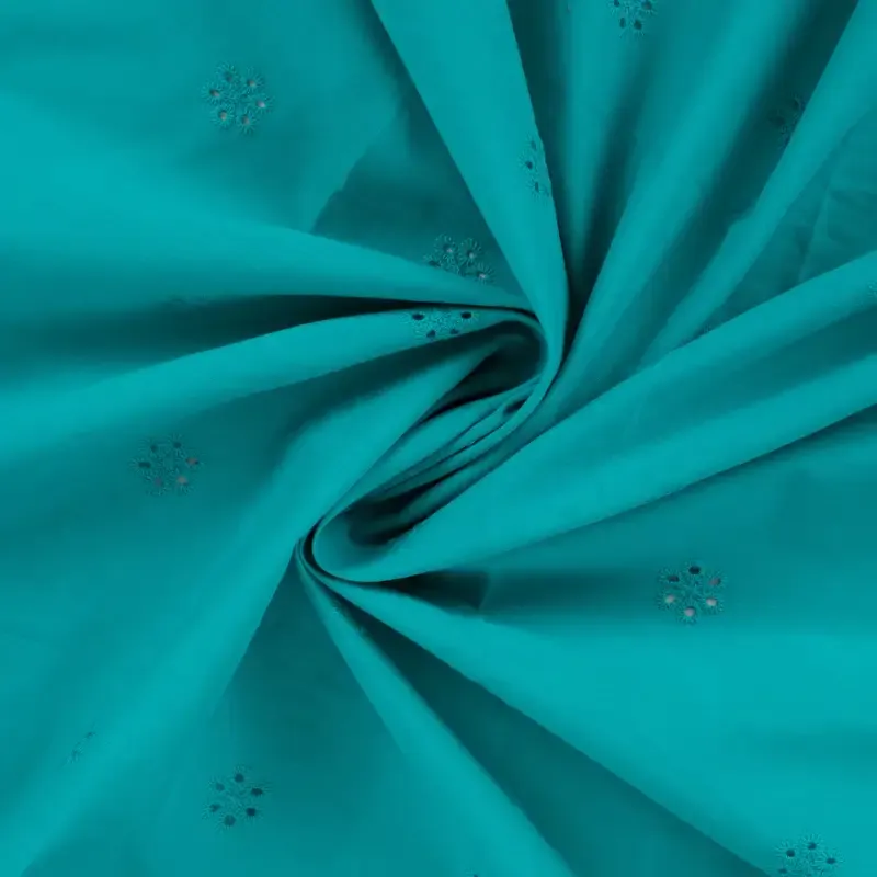 Broderie turquoise met bloemetjes en afgewerkte boord