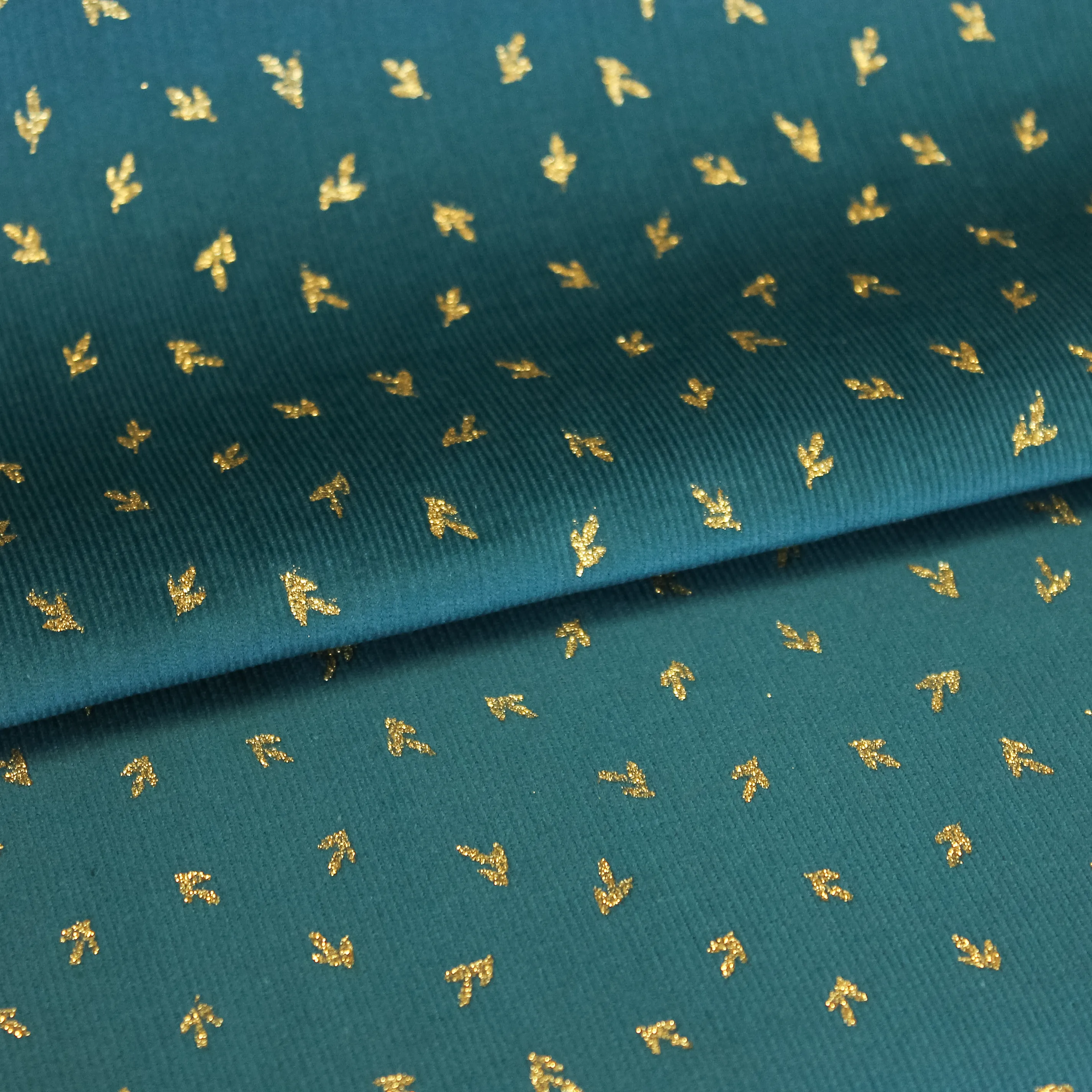 Turquoise ribfluweel met gouden glitter blaadjes