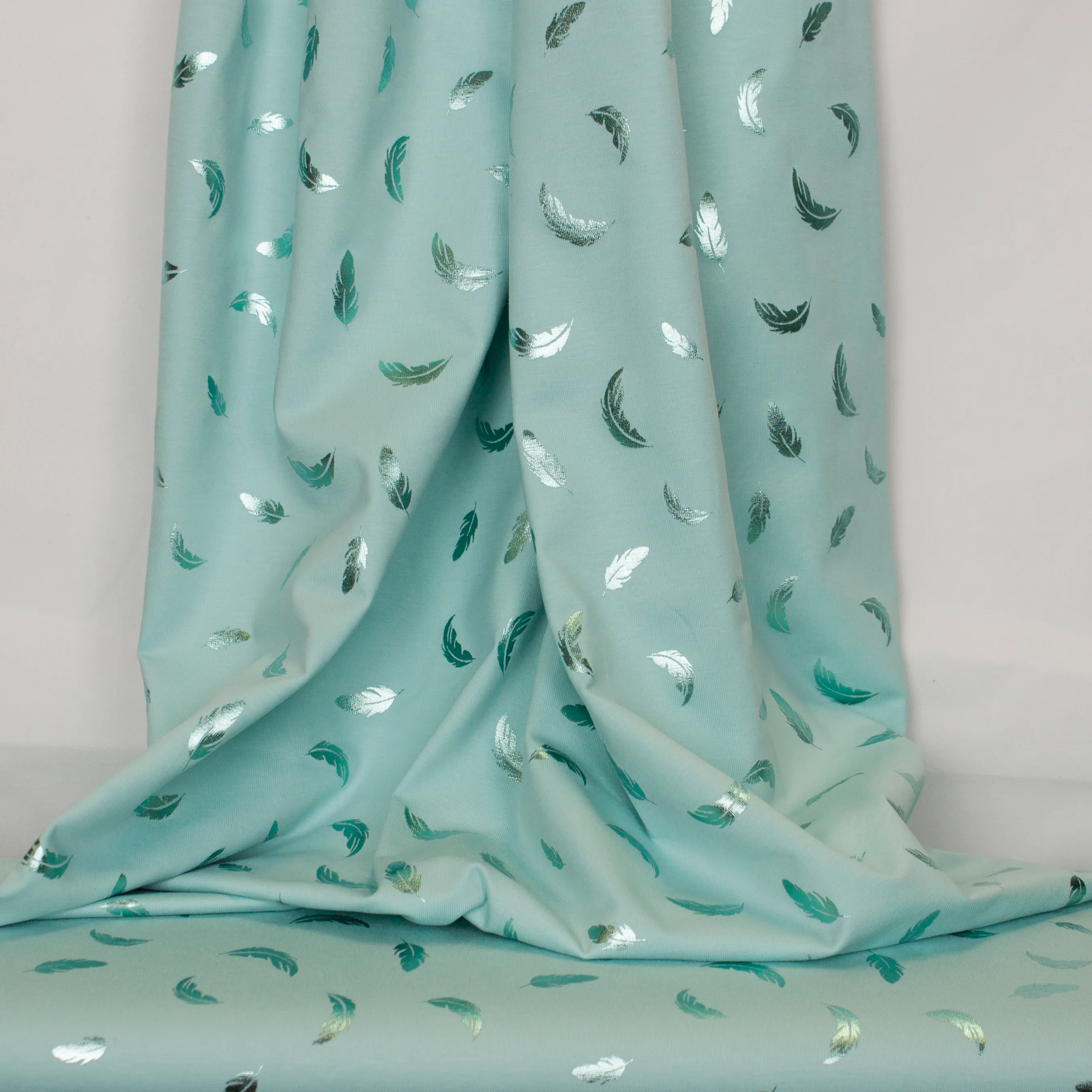 Turquoise tricot met weerspiegelende veertjes